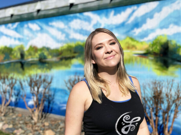 Lacy Wilson standing in front of her mural
