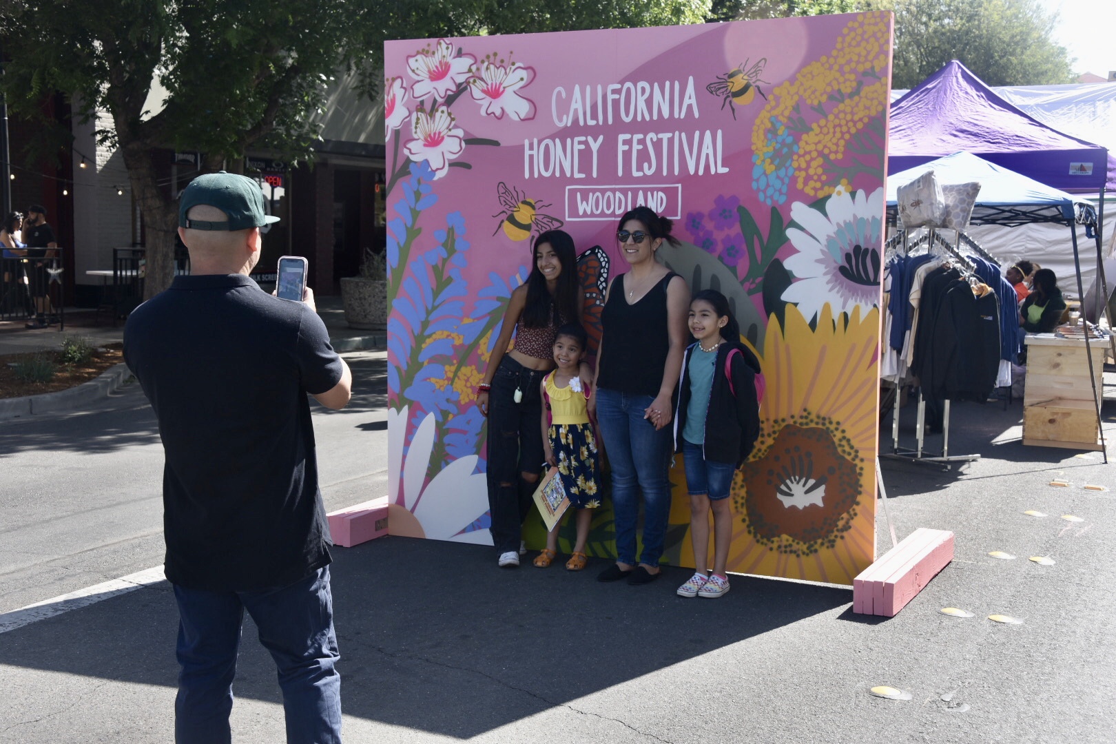 family taking a photo in front of California Honey Festival sign