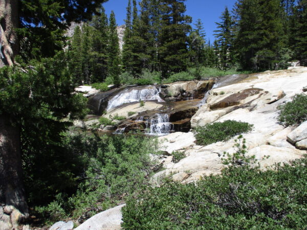 little waterfall over rocks along hiking trail