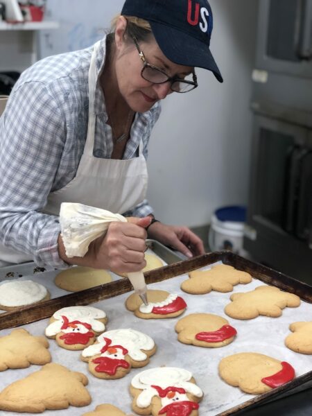 Worker makes frosted cookies